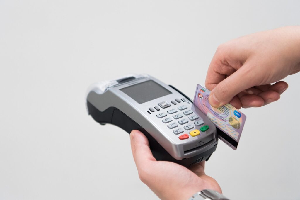 máquina passando um cartão de crédito simbolizando uma compra
